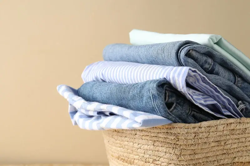 Neatly folded laundry organized in a woven basket
